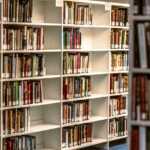 Neatly arranged books on white shelves in a library for easy browsing.